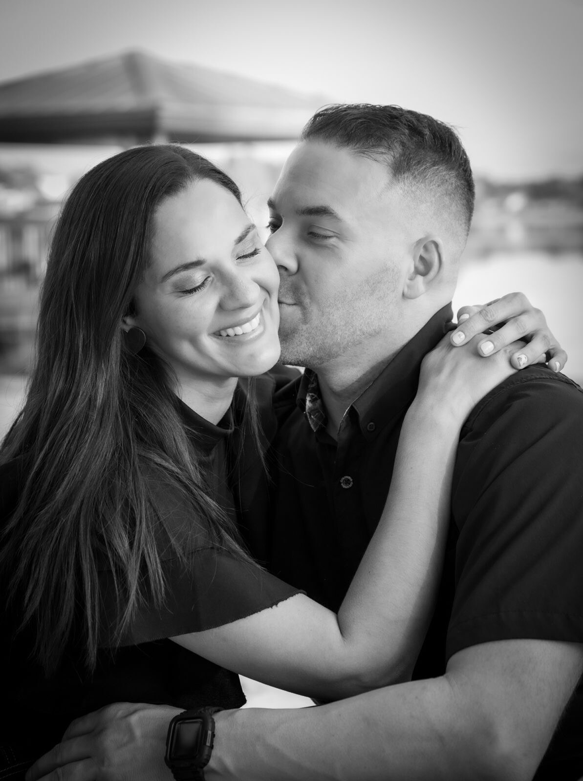 Couple embracing in a candid black-and-white portrait