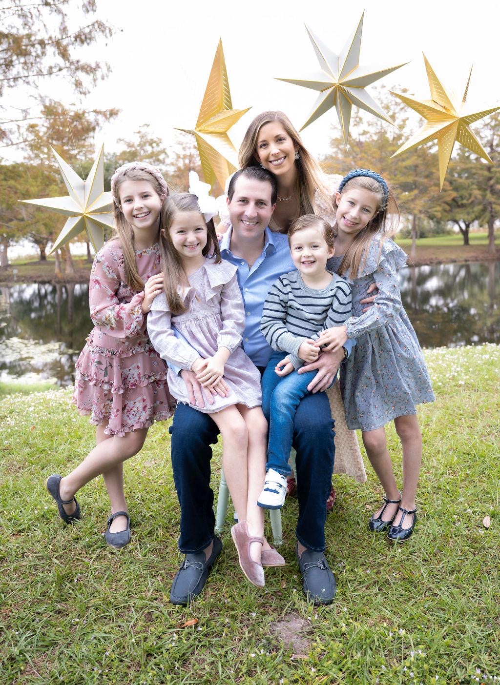 Family portrait outdoors beneath hanging gold stars