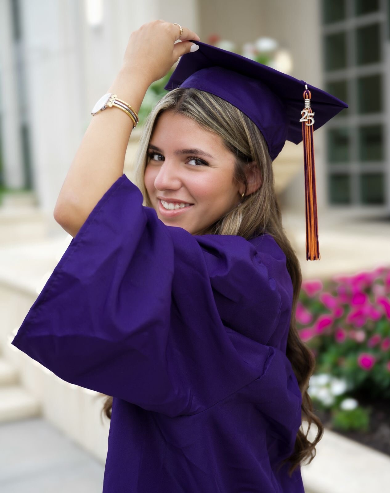 Graduate smiling in a purple cap and gown